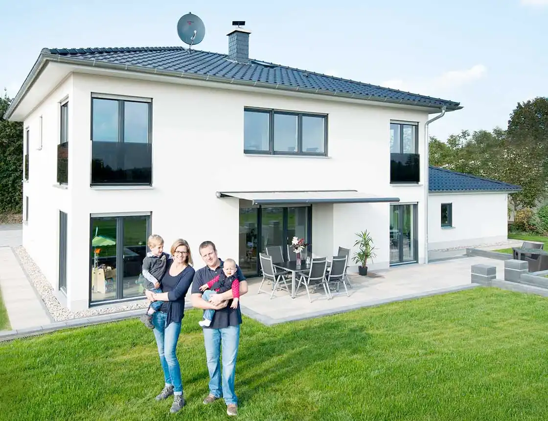 Familie vor modernem Einfamilienhaus.